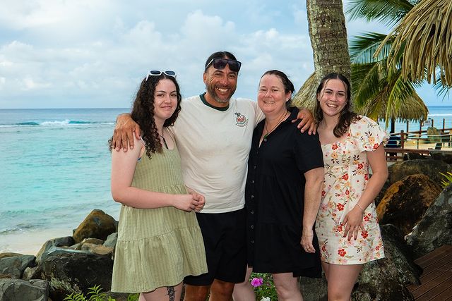 A happy family enjoying their tropical vacation at Edgewater Resort, Rarotonga, with stunning ocean views in the background.