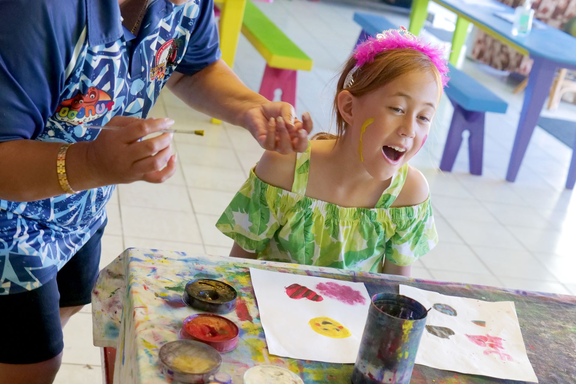 A young guest enjoying face painting and creative activities at Edgewater Resort’s family-friendly kids’ club.
